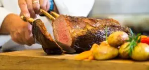 Chef carving roasted meat with vegetables for Hawke's Bay event catering