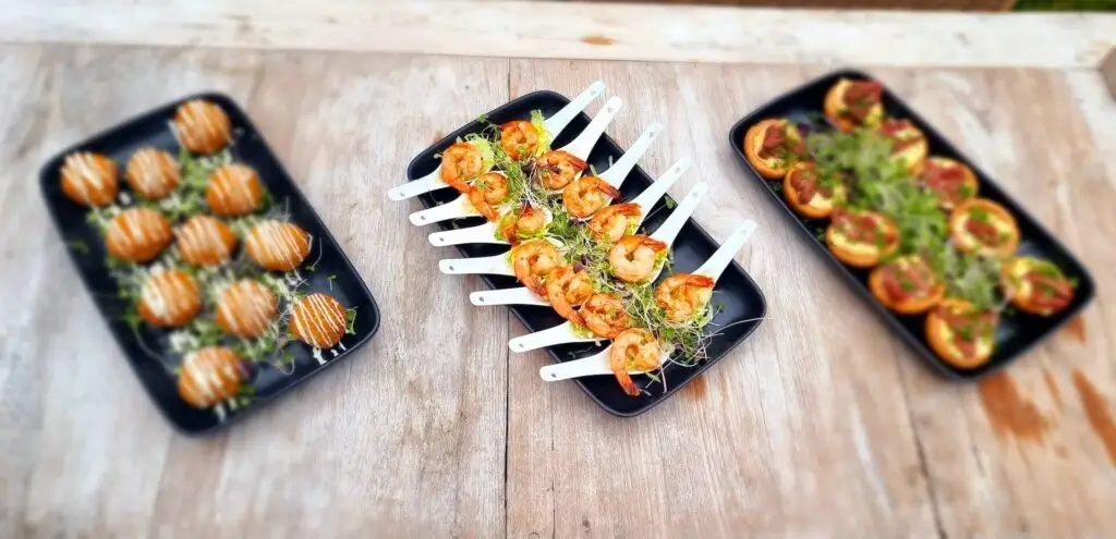 Three platters of canapés including prawn, tart and bruschetta bites